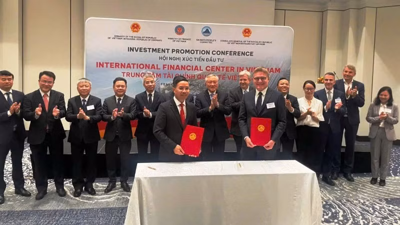 岘港市人民委员会主席范德印与法兰克福金融公司代表签署金融中心合作谅解备忘录。（图片来源：丁强 摄）