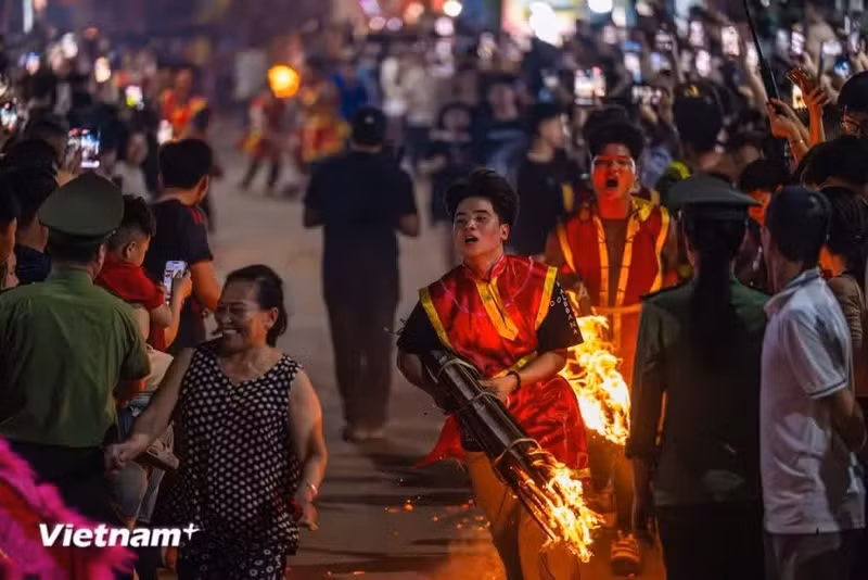 一支巨型火炬被立于村口，熊熊火焰燃起时，村民们纷纷驻足观看，兴奋不已。