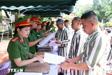 公安部富山四号监狱的狱警向2025年获得特赦（第二批）的人员颁发特赦证书。