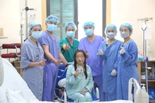 越德友谊医院的医生团队与越南首例同时实施心肺联合移植的患者合影。（医院供图）