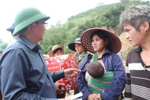 越南政府副总理胡国勇向玉岭乡受灾群众赠送慰问品。