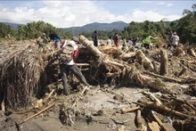 印尼西苏门答腊发生洪水和山体滑坡后，救援力量在现场搜寻遇难者。