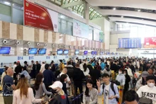 2月13日旅客在机场排队现场。（图片来源：越通社）