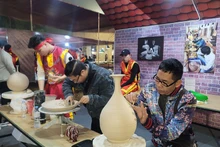 钵场陶瓷村陶瓷工艺师在钵场陶瓷村和万福丝织村加入全球创意城市网络“手工艺之都”证书授予仪式暨2025年河内手工艺品展示、演示与创作活动上介绍其村产品。（图片来源：越通社）