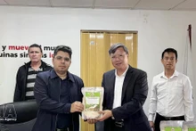 越南驻古巴大使黎光龙（右）向巴方代表象征性移交无偿援助大米。（图片来源：越通社）