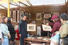 向游客介绍北宁的东湖画。（图片来源：越通社）