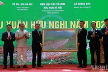 香山乡领导代表向春游代表团赠送了一幅描绘香山名胜群中燕溪的画作。