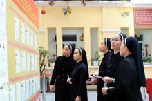 还剑郡第1投票区，31号圣十字会女修会的修女们在查看候选人名单。