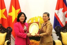 柬埔寨人民党（CPP）副主席、柬埔寨祖国发展团结阵线国家委员会主席梅森安向越南祖国阵线中央委员会主席裴氏明怀赠送纪念品。（图片来源：越通社）