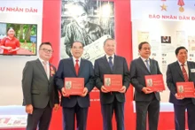 越共中央总书记苏林与党和国家领导同志及代表们在《人民报》社展区获赠《胡志明主席在〈人民报〉上发表的关于文化与新闻的文章选编》一书。