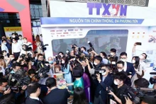 在2022年全国新闻展上,媒体记者报道关于越通社的展位。(图片来源:越通社)