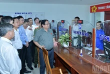 范明正总理对兴富坊公共行政中心行政手续办理情况进行检查。（图片来源：越通社）