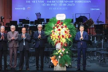 越南友好组织联合会主席潘英山（右一）向越美友好协会送花表示祝贺。（孟阮 摄）