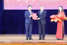 越共中央组织部部长黎明兴向梁阮明哲同志授予任免决定书。（图片来源：人民报）
