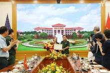 越共中央委员、中央军委常委、国防部副部长黄春战上将向美国国际开发署（USAID）驻越南首席代表阿勒·格拉布斯授予奖状。（图片来源：越通社）
