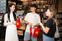 向国际游客赠送越南国旗。（图片来源：越通社）