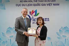 越南国家旅游局副局长阮氏花梅向阿塞拜疆旅游局首席执行官弗罗瑞恩·斯契米德赠送纪念品。(图片来源:TITC)