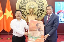 越南《人民报》驻京机构负责人向越南驻华大使范清平赠送越南《人民报》特刊及专题副刊。