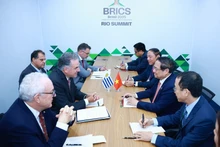 越南政府总理范明正在2025年7月7日举行的金砖国家（BRICS）扩展峰会期间会见乌拉圭总统亚曼杜·奥尔西。