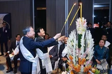 越共中央总书记苏林同通伦·西苏里同志共同进行老挝传统拴线仪式。