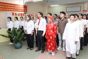 106岁的研究家阮廷思身穿红色奥黛，于3月15日上午参加投票。