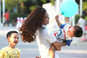 周末，一位母亲和孩子玩耍，脸上洋溢着幸福的笑容。