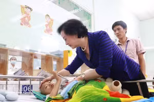 越共中央书记处书记、政府副总理范氏清茶亲切看望并鼓励正在胡志明市第二儿童医院接受治疗的患儿。（图片来源：越通社）