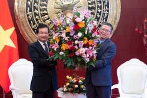 宋蓬·西加伦大使向范清平大使赠送花篮。