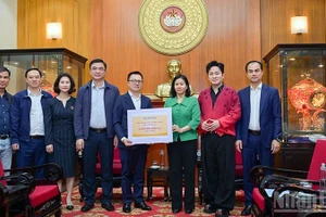 《人民报》社总编辑黎国明移交援助灾区同胞的善款。（宝龙 摄）