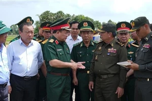 越南国防部副部长黄春战中将（左三）与柬埔寨皇家陆军副总司令伊萨拉将军（右二）讨论在柬埔寨柴桢省柴桢县建设桑索瓦纳小学友谊项目计划。（图片来源：越通社）