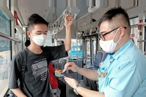 河内交通运输公司的员工使用手持设备销售和管理公交车票。（图片来源：新河内报）