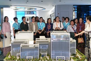 越南妇联常务副主席杜氏秋草等东盟妇女代表倾听工作人员现场讲解。
