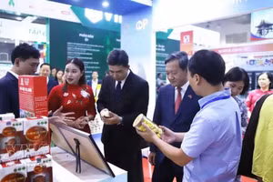 越南驻老大使阮明心和老挝工贸部副部长普塔万·南塔翁参观越南展位。