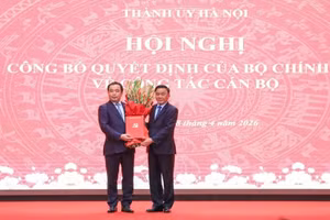 越共中央政治局委员、中央书记处常务书记陈锦秀向新任河内市委书记陈德胜授予决定并送花祝贺。