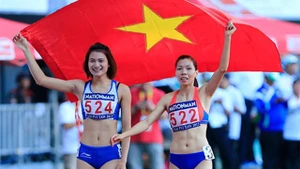 阮氏莺和武氏香手中高举国旗表示庆祝。（图片来源：越南快讯报网）