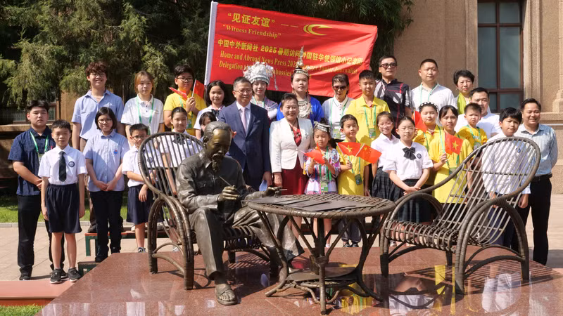 范清平大使和两国少儿在大使馆花园里的胡伯伯铜像合影。