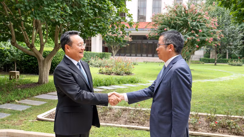 越南驻华大使范清平与中共中央宣传部副部长王纲握手。