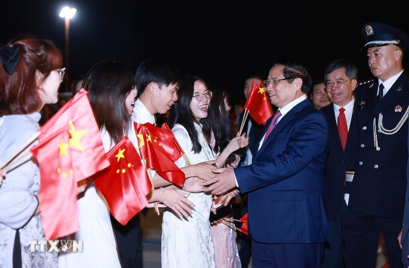旅居中国越南人代表前来机场迎接越南政府总理范明正一行。（图片来源：越通社）