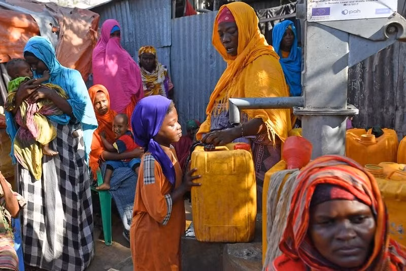 2017年，一名小女孩在索马里首都摩加迪沙的一个境内流离失所者难民营里取水。（图片来源：新华网）