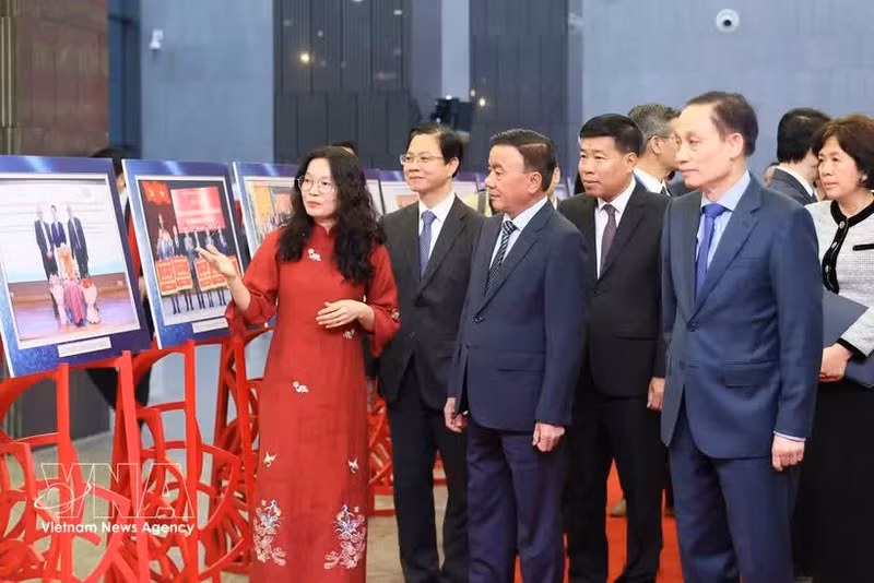 越共中央政治局委员、中央书记处常务书记陈锦秀与各位代表参观2025年民间外交工作成就图片展。（图片来源：越通社）