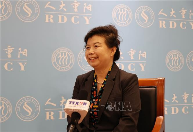 中国人民大学重阳金融研究院研究员刘英（右）接受越通社记者的采访。图自越通社