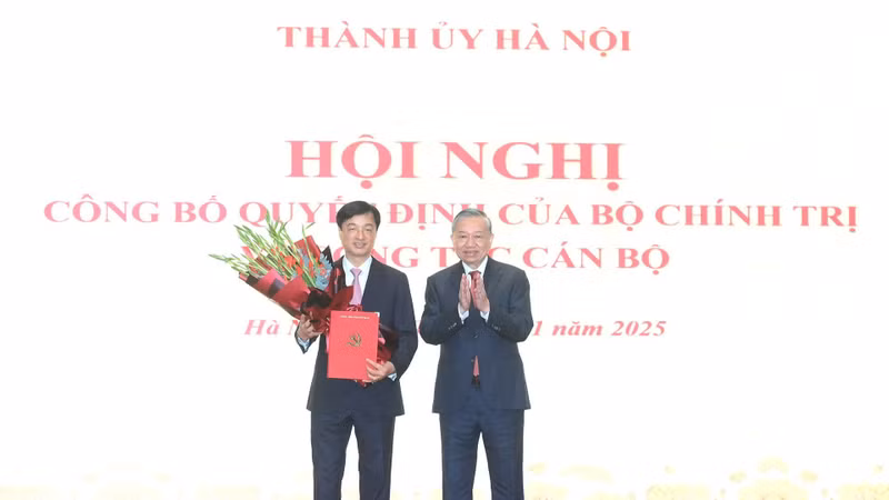 苏林总书记向阮维玉颁发决定书，并送花祝贺。