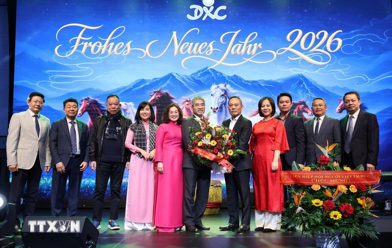 越南驻德大使阮得成与夫人以及越南驻德大使馆工作人员向同春购物中心总经理阮文贤和领导班子送花。（图片来源：越通社）