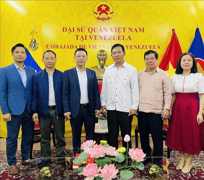 越南友好组织联合会代表团与越南驻委内瑞拉大使馆代表合影。