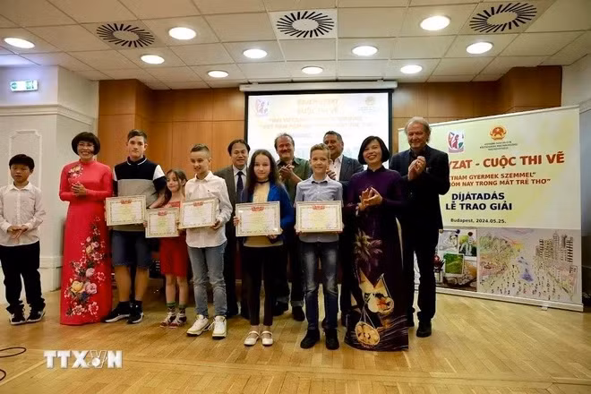 越南驻匈牙利大使阮氏碧草和旅居匈牙利越南妇女协会主席潘碧善与获奖学生合影。