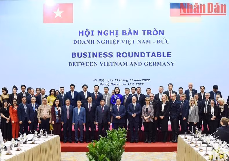 越南政府总理范明正和德国总理奥拉夫·朔尔茨同越德企业代表合影。（陈海 摄）