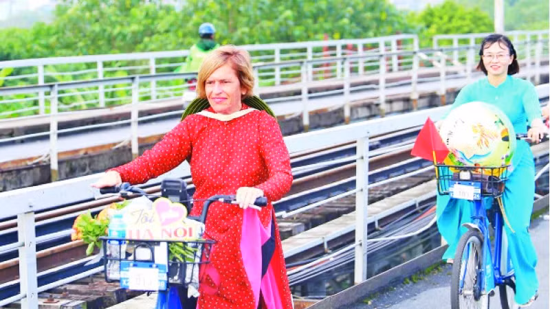 英国人斯特拉·乔拉骑自行车，宣传越南传统奥黛。