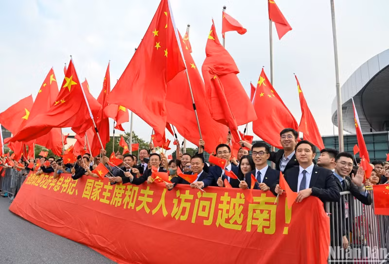 人们向中共中央总书记、中国国家主席习近平和夫人挥手致意。