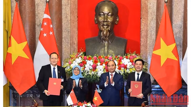 越南国家主席阮春福与新加坡总统哈莉玛•雅各布见证两国工贸部之间的合作备忘录签字仪式。