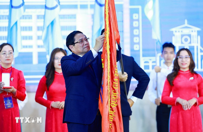 范明正总理代表党和国家领导人向胡志明市国家大学颁发一级劳动勋章。（图片来源：越通社）